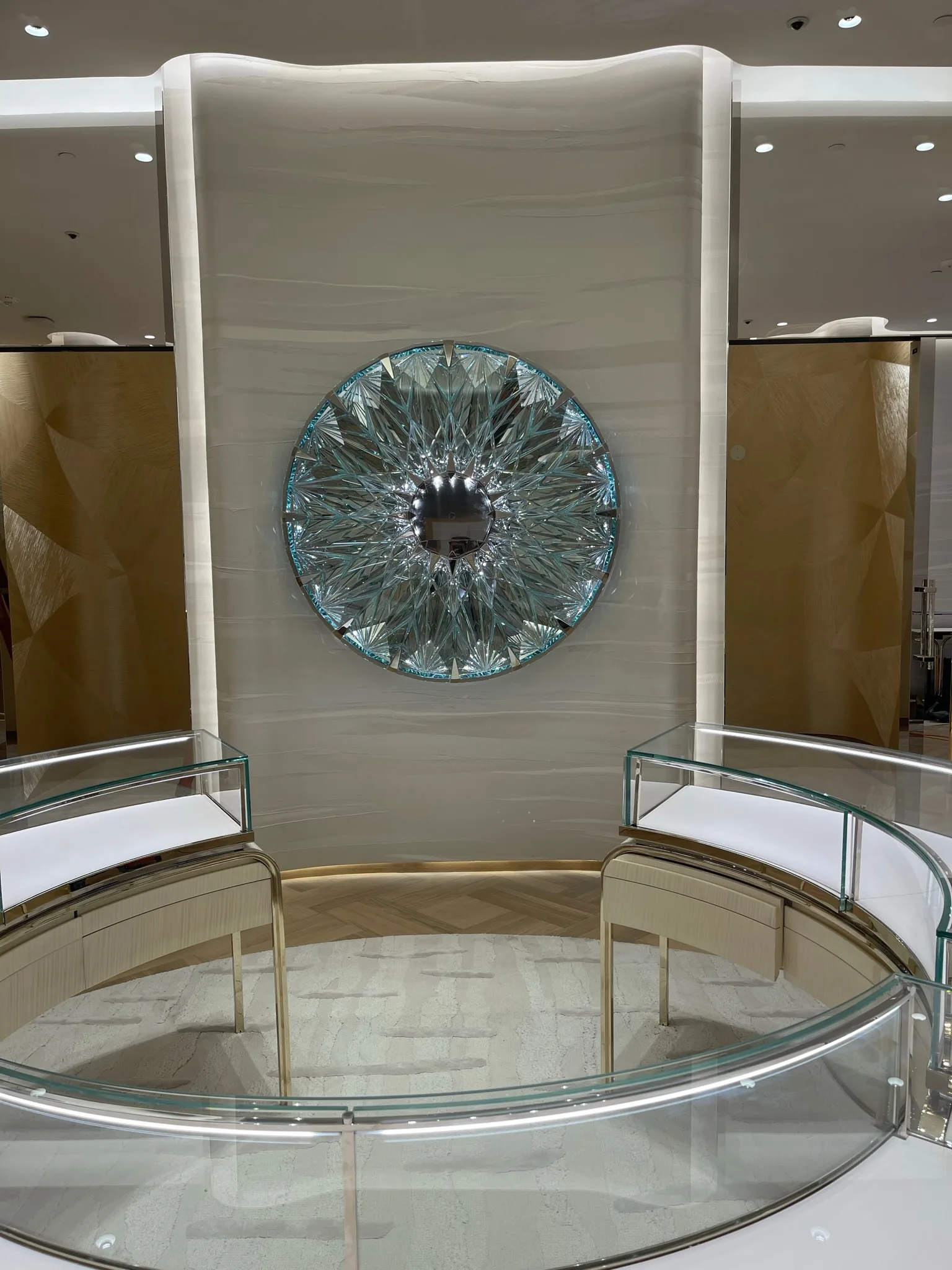 Light oak herringbone flooring beneath the crystal sunburst wall at Tiffany & Co. Glendale