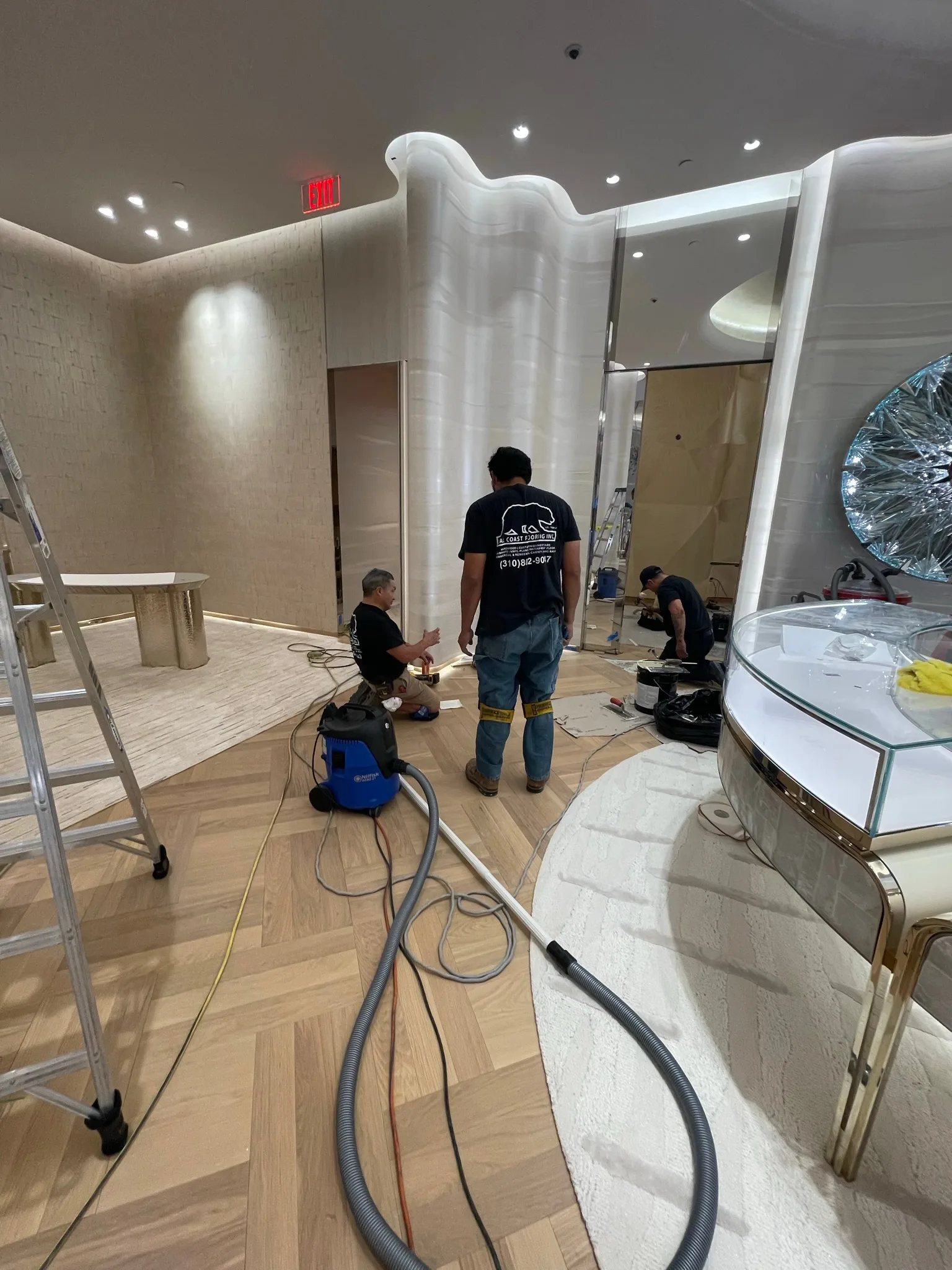 Cal Coast Flooring crew finishing details on the oak herringbone floor at Tiffany & Co. Glendale