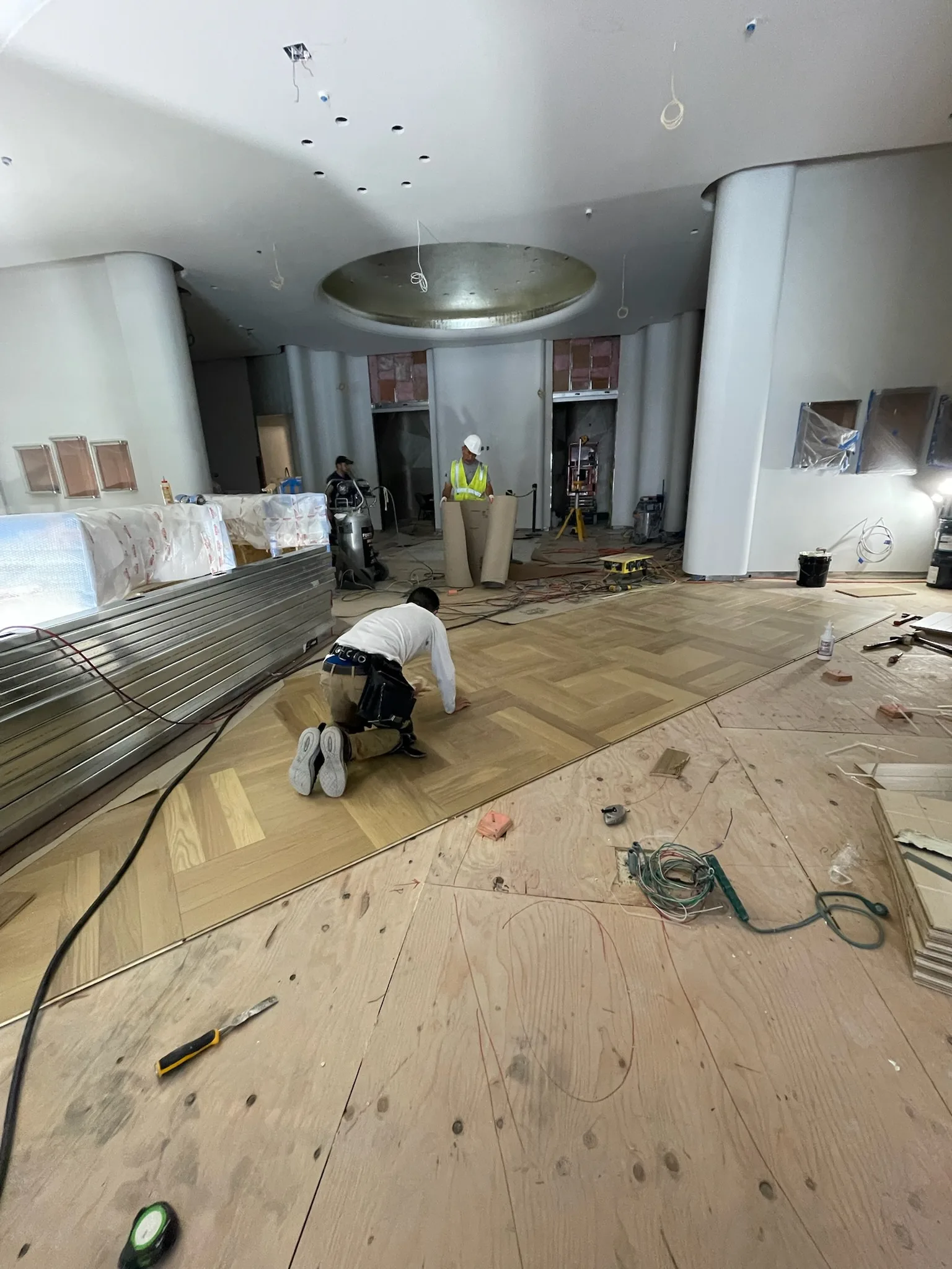Oak parquet field mid-install beneath the gold dome ceiling at Tiffany & Co. Glendale