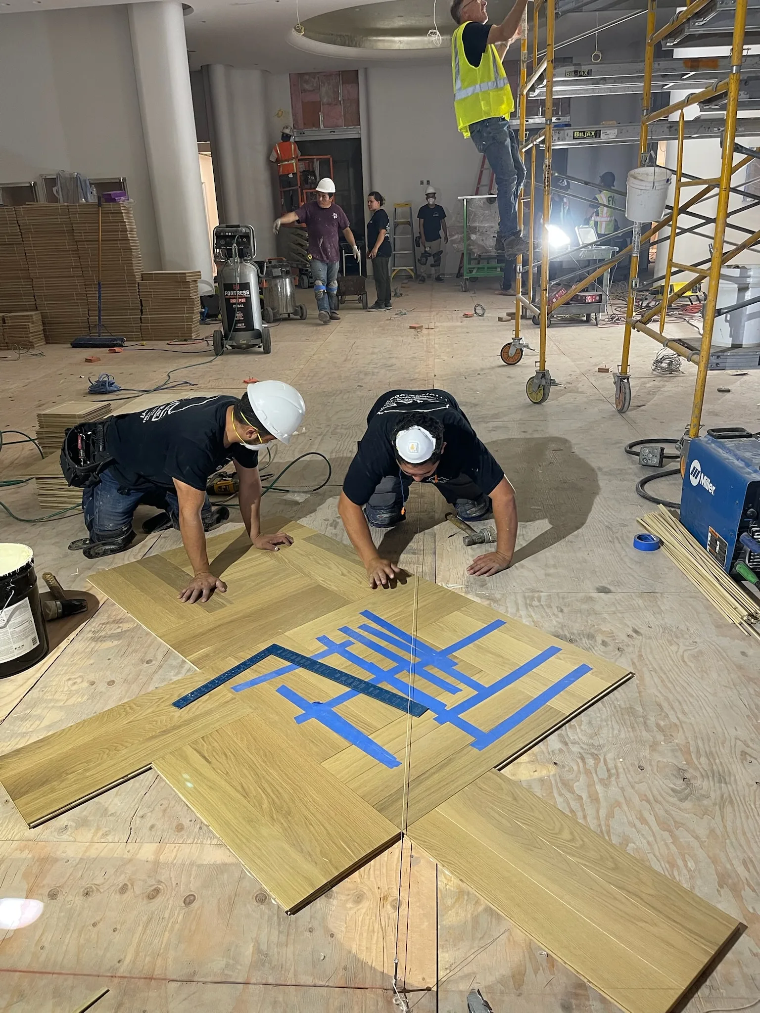 Cal Coast Flooring installers assembling a taped oak parquet panel at Tiffany & Co. Glendale