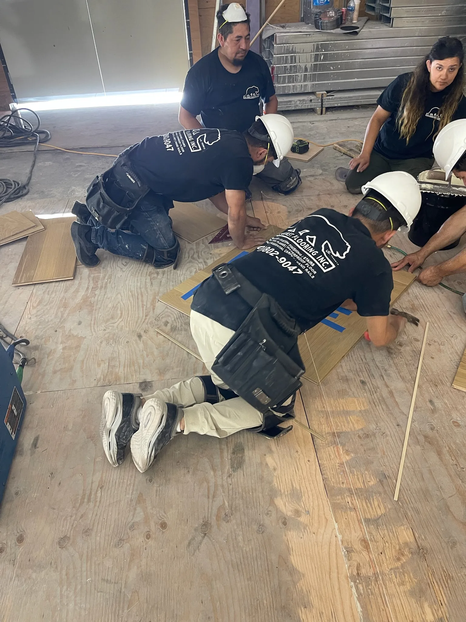 Cal Coast Flooring installation team laying oak flooring panels at Tiffany & Co. Glendale