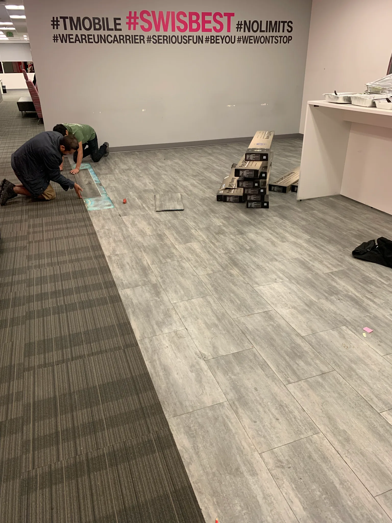 Gray wood-look plank flooring meeting carpet tile in a tenant office at the Wedgewood building