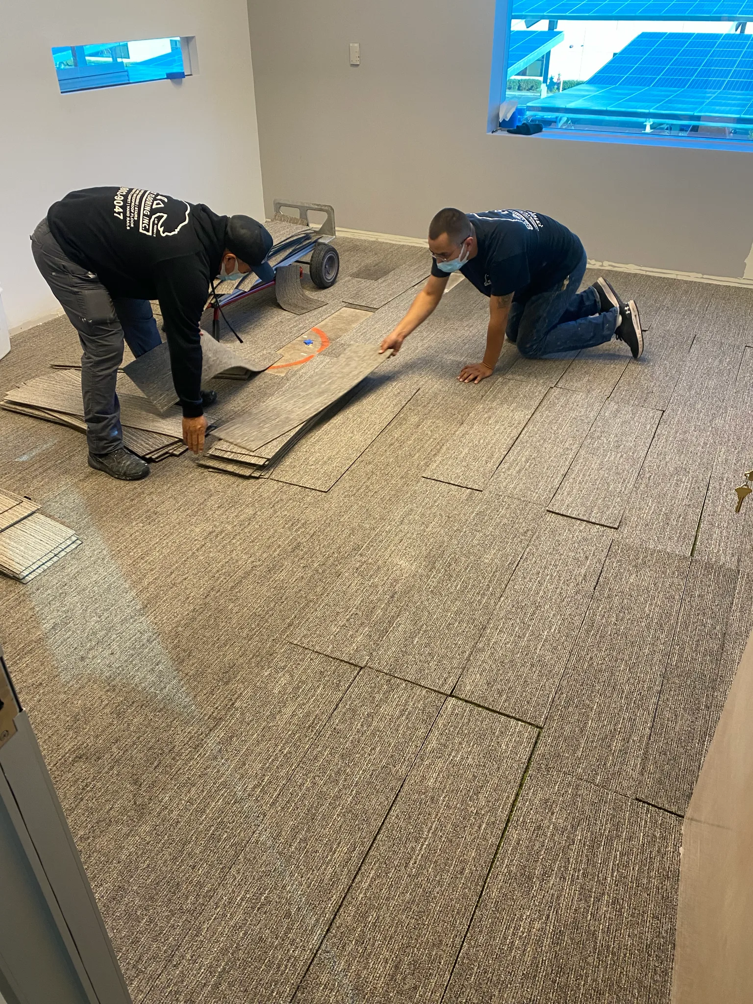 Cal Coast Flooring installers fitting carpet tile in a private office at the Wedgewood building