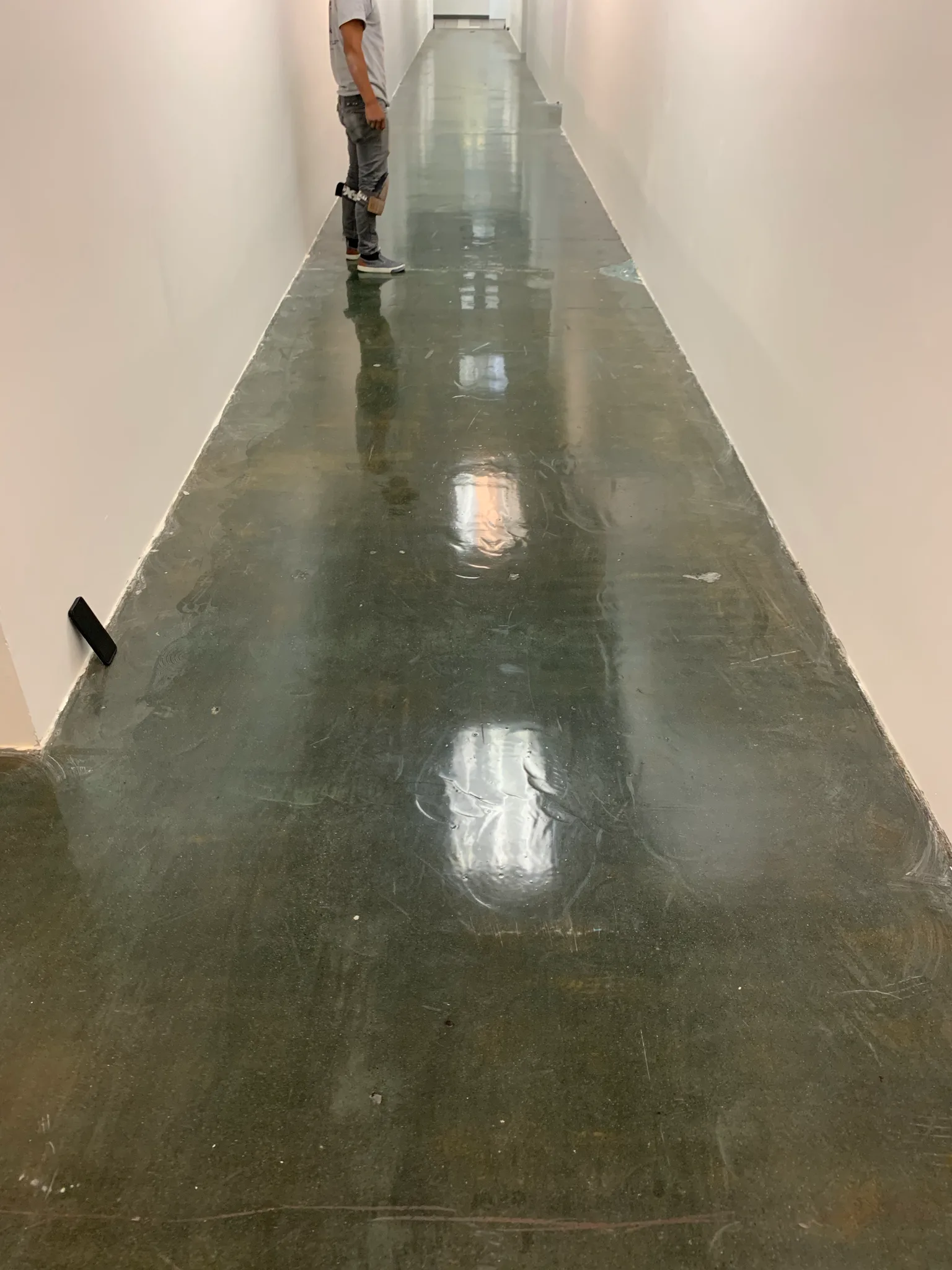 Moisture barrier down the length of a corridor slab at the Wedgewood building before flooring