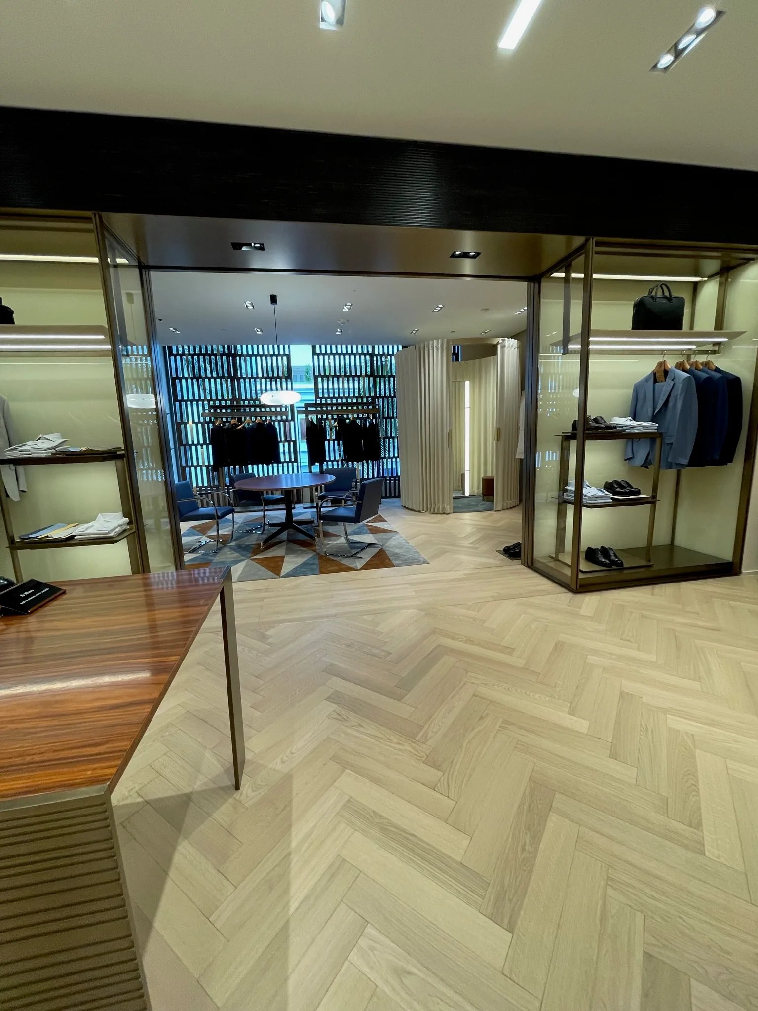 Light oak herringbone flooring between suit displays in the Zegna Beverly Hills menswear salon