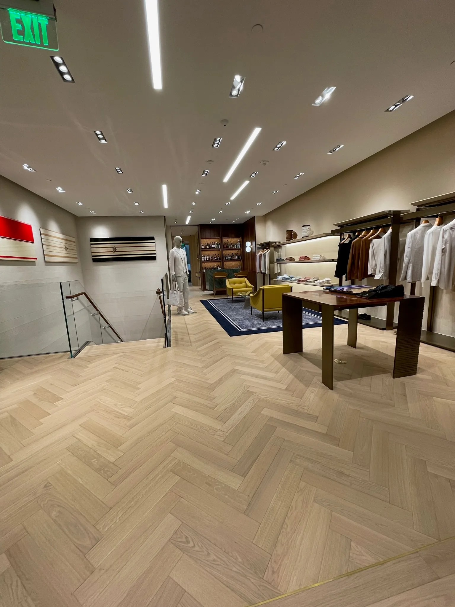 Light oak herringbone flooring around the stairwell opening at Zegna Beverly Hills