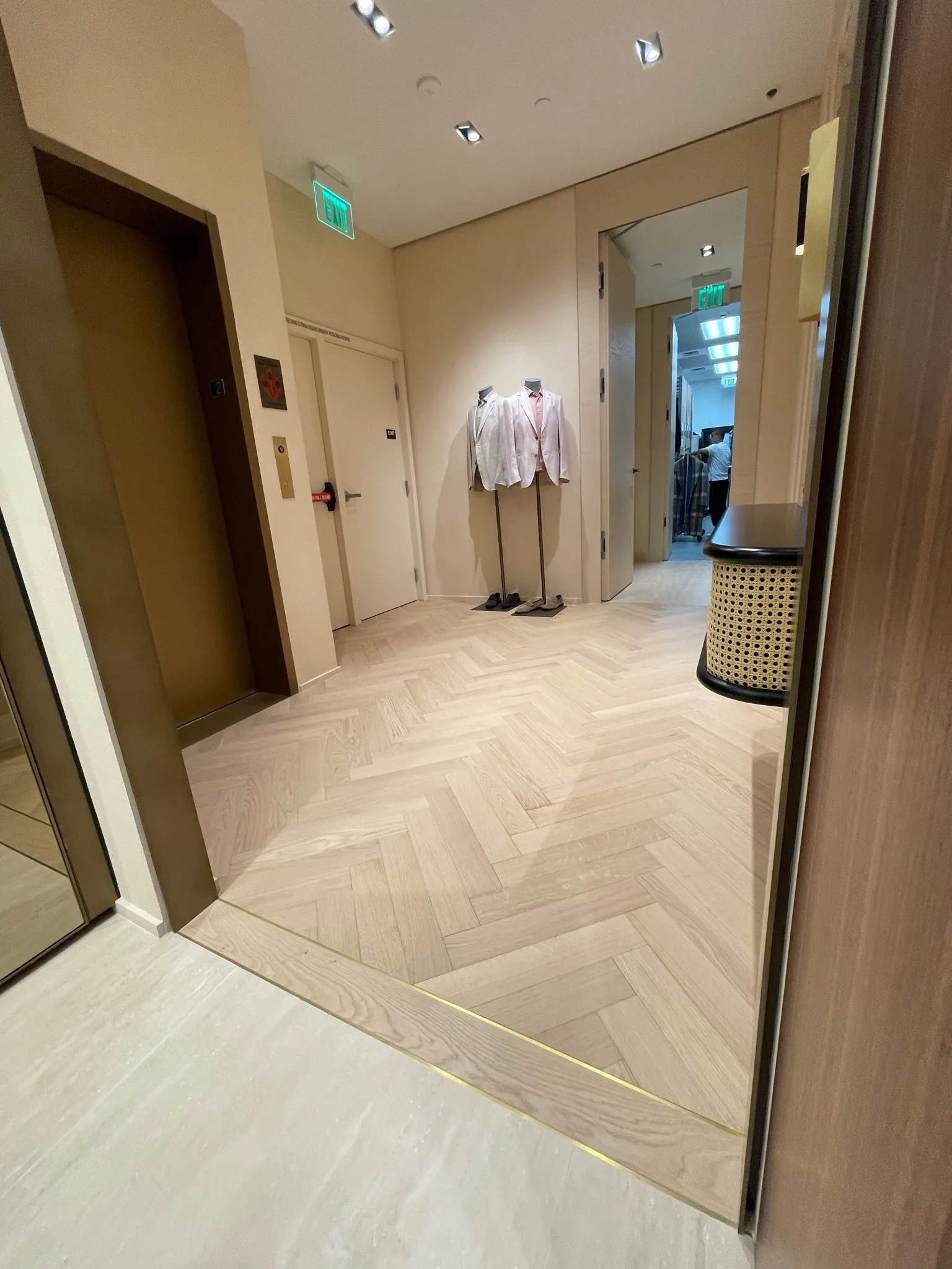Prefinished oak herringbone floor meeting a metal transition strip in the Zegna Beverly Hills lobby