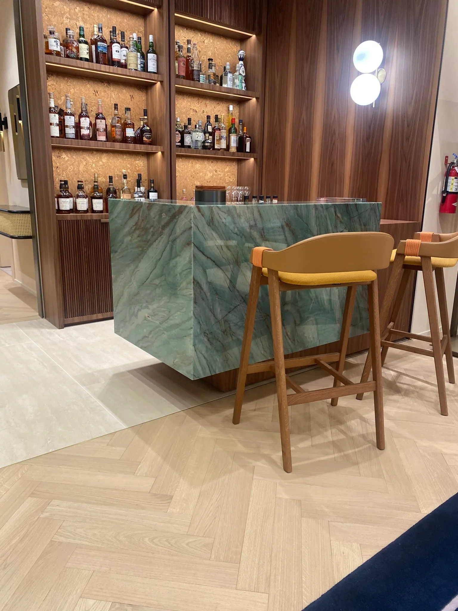 Oak herringbone flooring at the green-marble bar in the Zegna Beverly Hills lounge